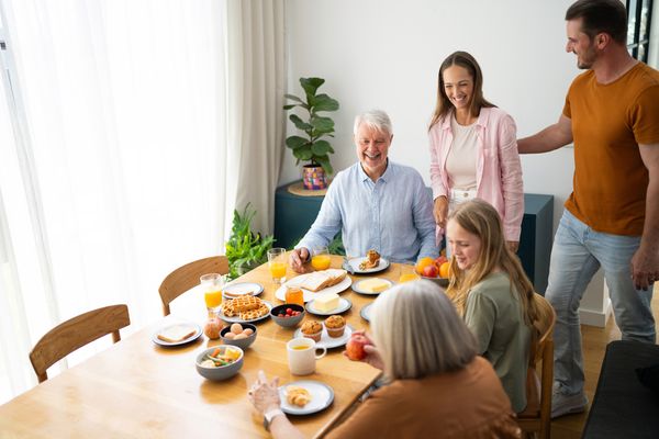 iStock Credit: SrdjanPav A family enjoying breakfast in a dining room
