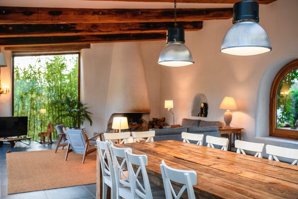 A wide shot of an open dining room and living room featuring a farmhouse table