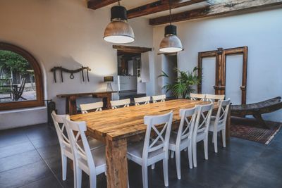 A farmhouse dining room featuring a wooden table and white chairs