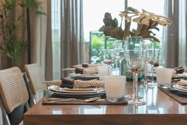 A close-up of a formal dining table with dinnerware and glassware 