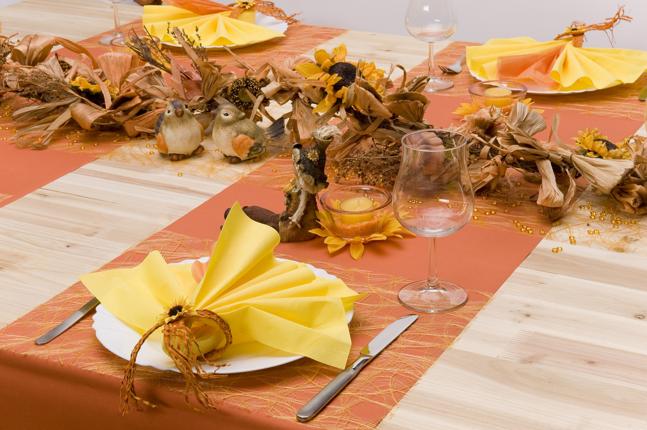 fall themed table with orange decorated table runners across tabletop