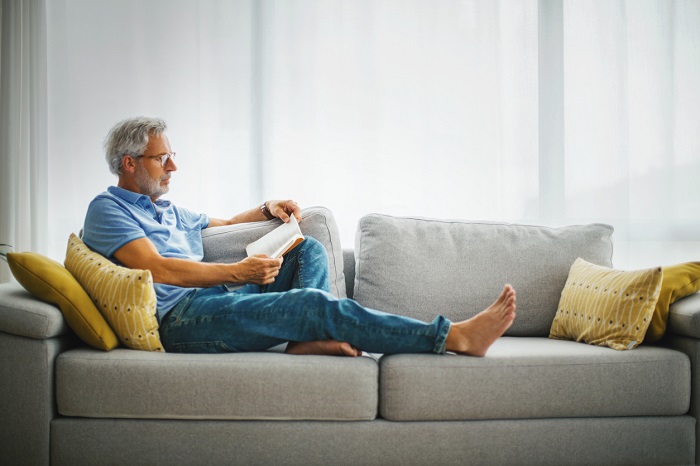 Man reading a book on the sofa.