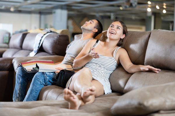A man and woman sampling a leather sofa