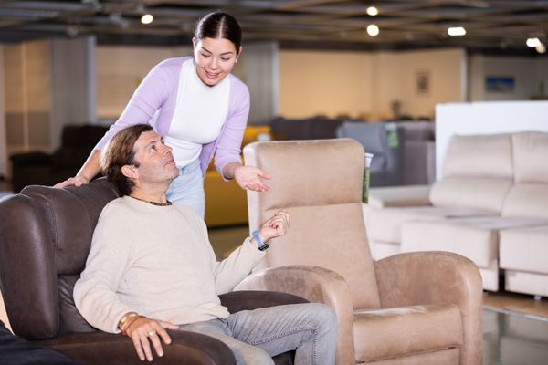 A man testing a recliner in a store 