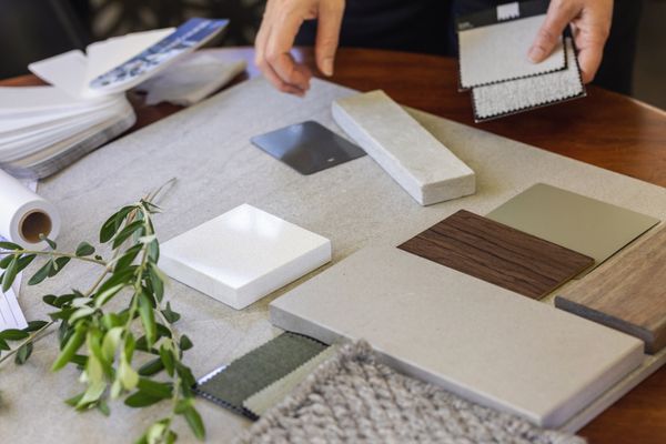A person comparing material samples on a table 