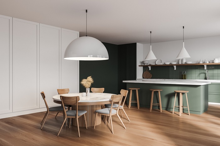 Modern kitchen and dining area with wooden chairs, a table, and barstools in the background.
