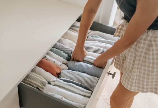 A woman organizing clothes in a dresser