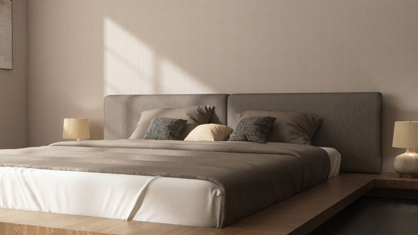 A platform bed with neutral bedding 