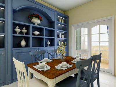 A Provencal-style dining room with blue built-in cabinetry and rustic furniture 