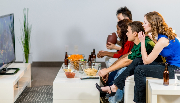Friends watching football with a convenient coffee table and side table