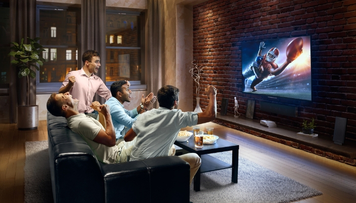 Group of friends watching football in the living room