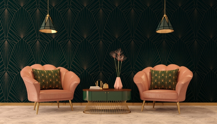 Two pink shell chairs sit in front of a dark green, elaborate wall paper. 