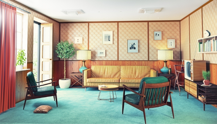 A mid-century living room with a yellow couch and green accent chairs facing a TV. 