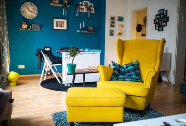 front view of a blue and yellow living room with a yellow accent chair and ottoman