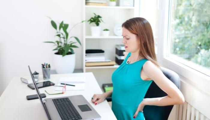 Woman in home office with back pain