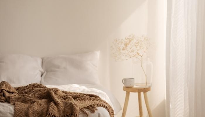 Stool being used as a nightstand next to bed