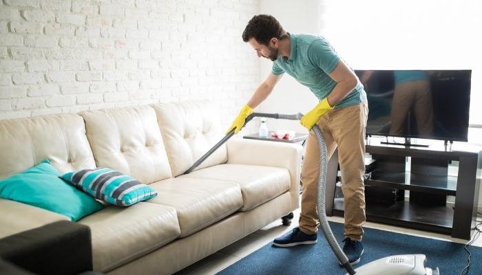 Man vacuuming couch