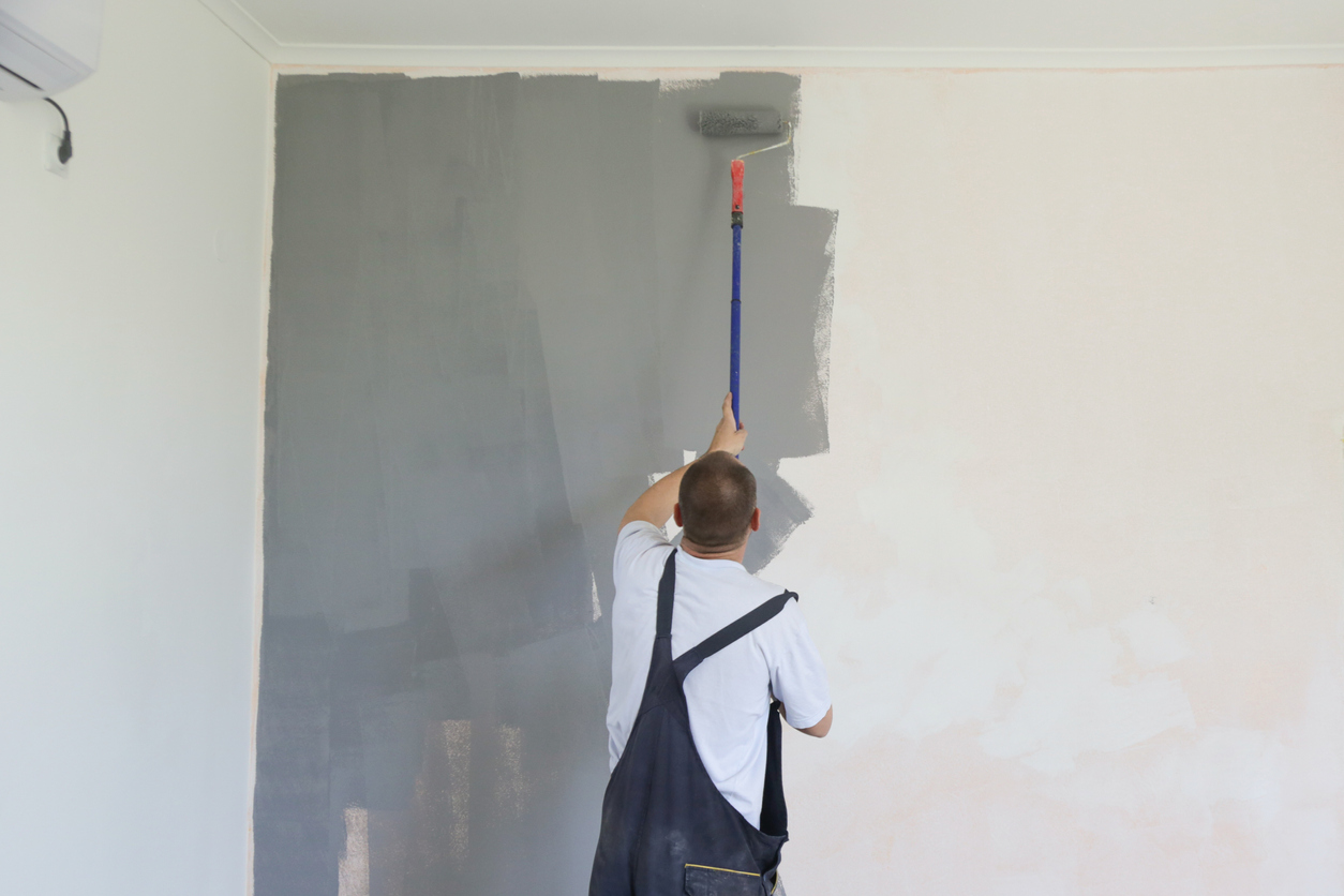 man painting bedrooom grey
