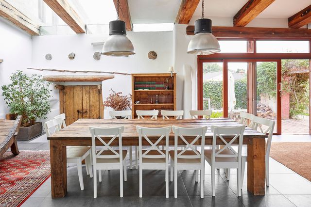 front view of a modern farmhouse dining room table with 12 white chairs around it