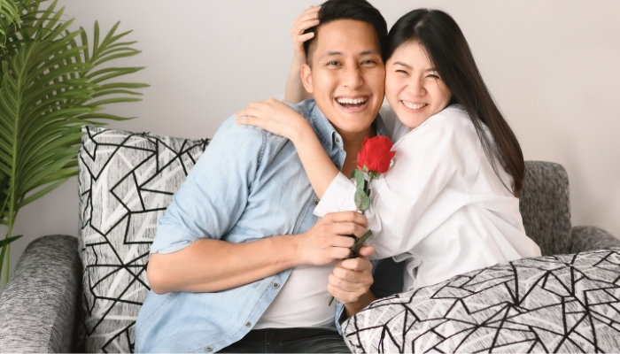 Couple cuddling on loveseat for Valentine’s Day