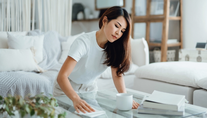 Woman wiping down glass table