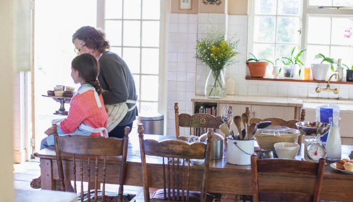 Mother and daughter sitting on a table with mixed chairs