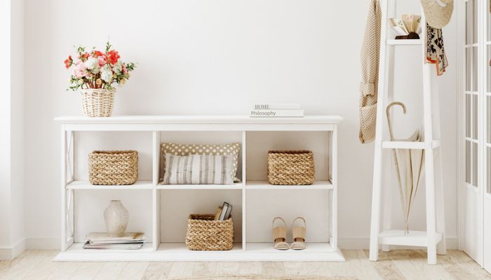 White entryway with a white storage entryway table and coat rack