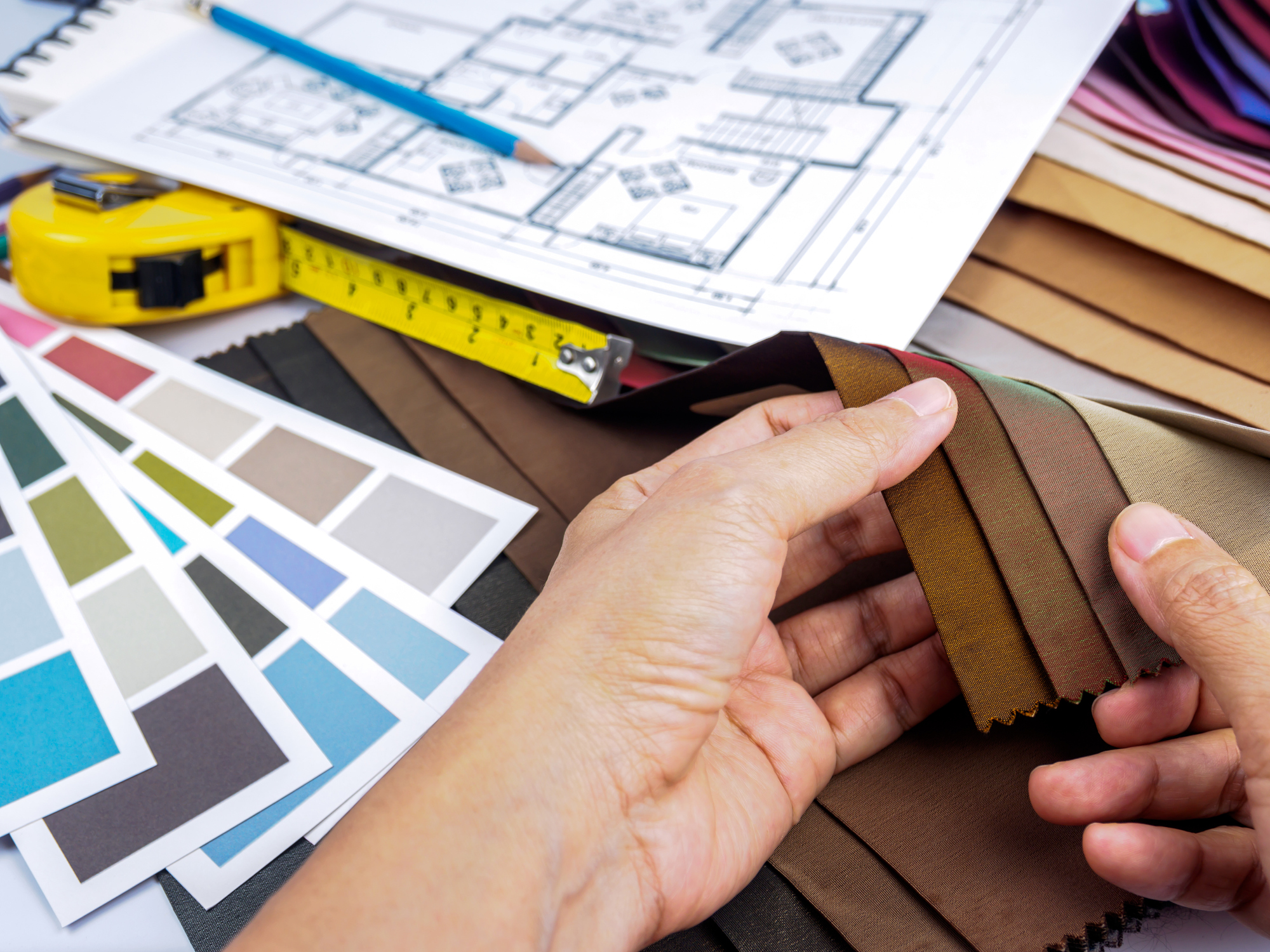 A hand sorts through different color swatches and fabric samples