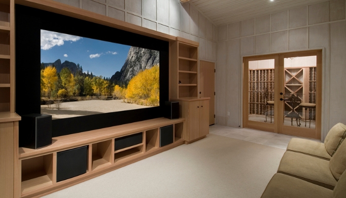 A media room with a large natural wood wall entertainment unit.