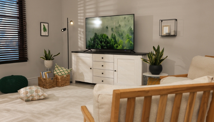 A distressed white media chest with a flat screen TV on top.