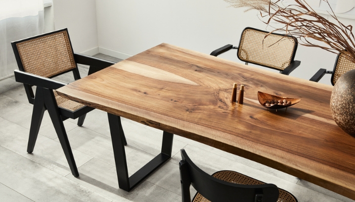A wooden dining room table with black metal accents.
