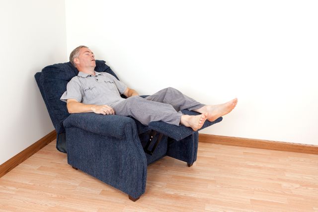 front view of a man sleeping in a blue recliner