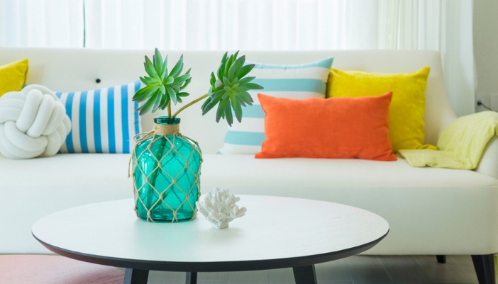 A neutral couch with throw pillows in bright colors.