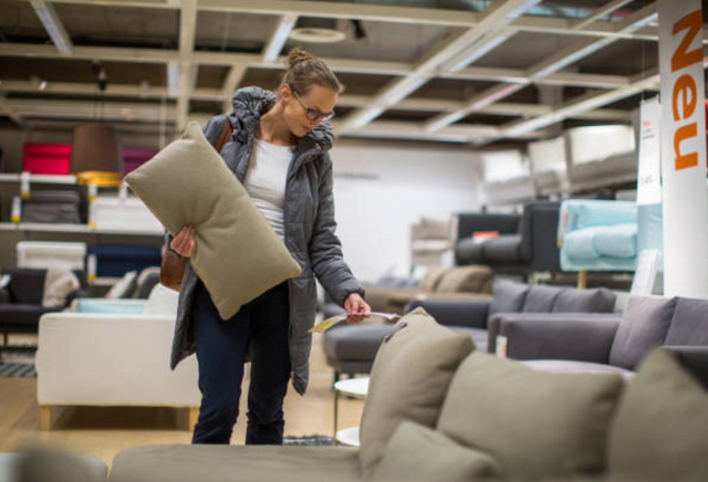 front view of a woman examining a sectional in a furniture store