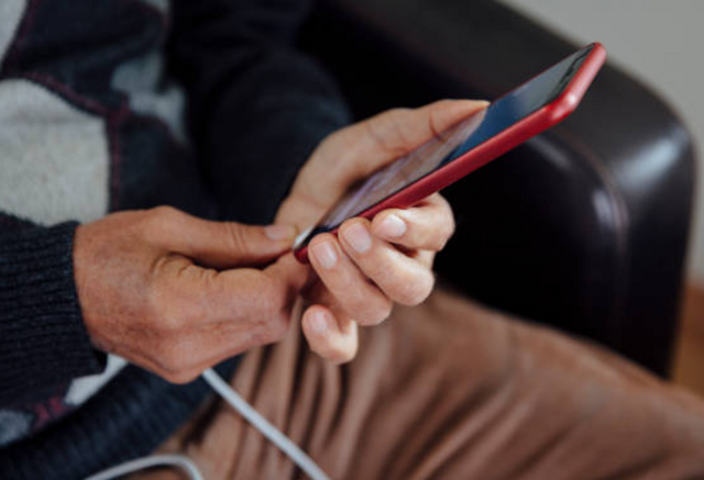 Close view of a man plugging in his phone with a USB from the sofa