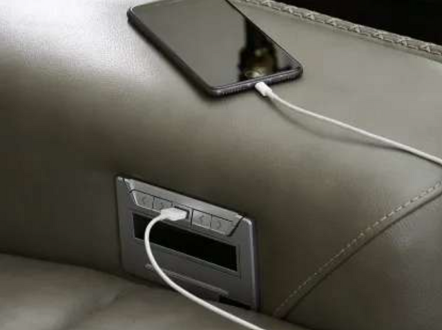 close view of a phone charging with a USB charger in a sofa
