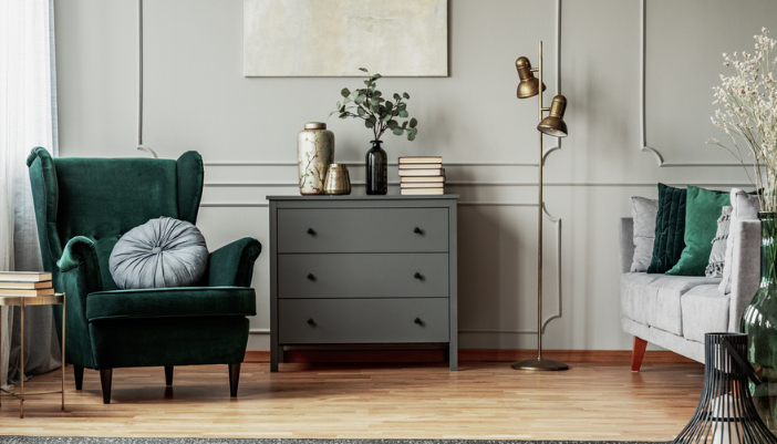A home seating area with a green velvet arm chair and warm other accents.