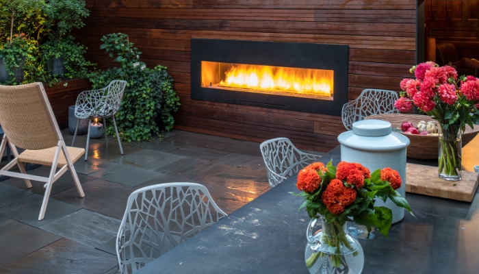 Outdoor dining space with built-in fireplace into the wall
