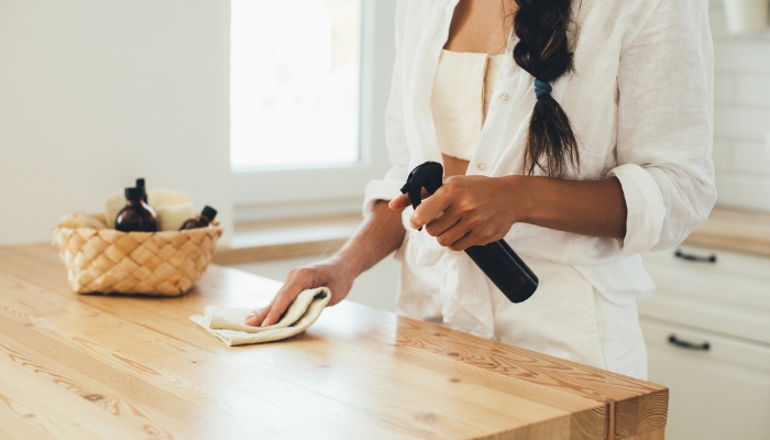 Woman cleaning wood furniture with homemade solution