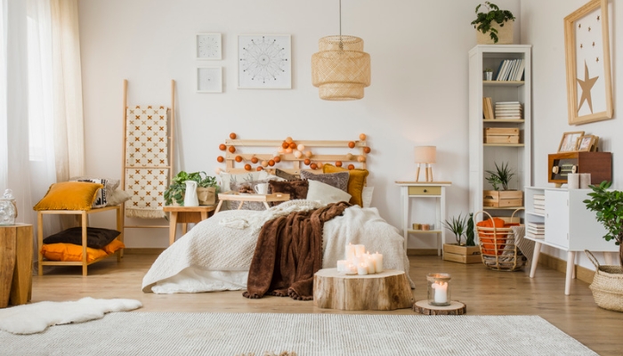 A bright, neutral colored bedroom with bohemian and white decor