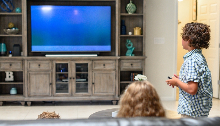 Family watching TV that’s been secured to the entertainment center