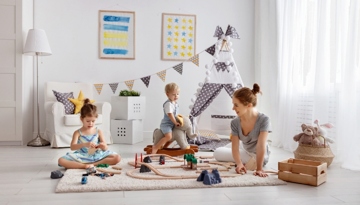 A mother and two children playing on the floor with an  anti-slip rug