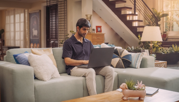 A man working from home on an upholstered couch with high-quality fabrics