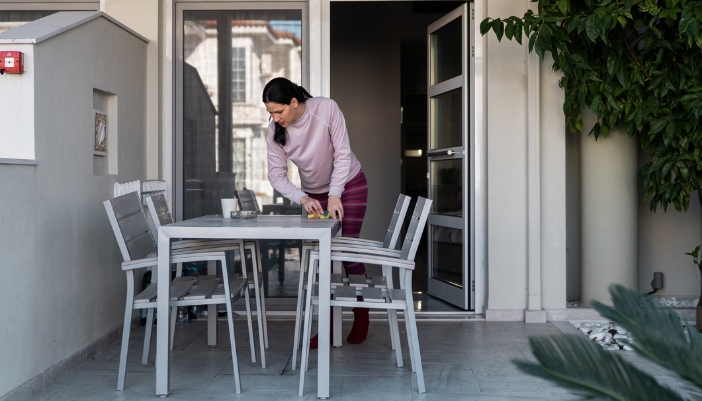 Woman cleaning her outdoor patio dining table