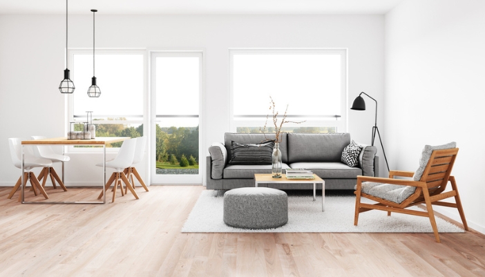 An open floor plan dining room and living room with neutral and wood furniture.