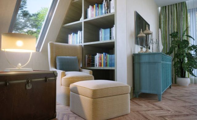 low angle view of a bedroom reading nook with a chair and ottoman