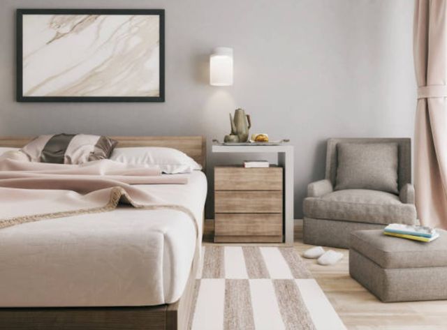 front view of a modern minimalist bedroom with an accent chair and ottoman