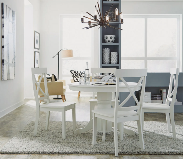 front view of a modern bright white dining room with a white round table and matching chairs