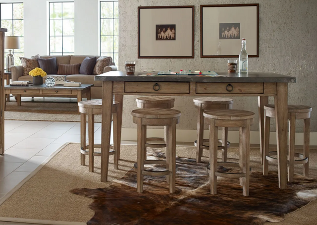front view of a modern rustic style open concept dining room with living room in the background. The dining table is surrounded by six wooden counter height stools