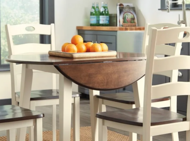 close view of a round wooden farmhouse extension leaf dining table with the leaf down